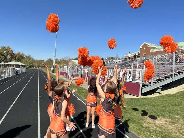 Jr Pacers cheerleaders raise their poms in a stunt