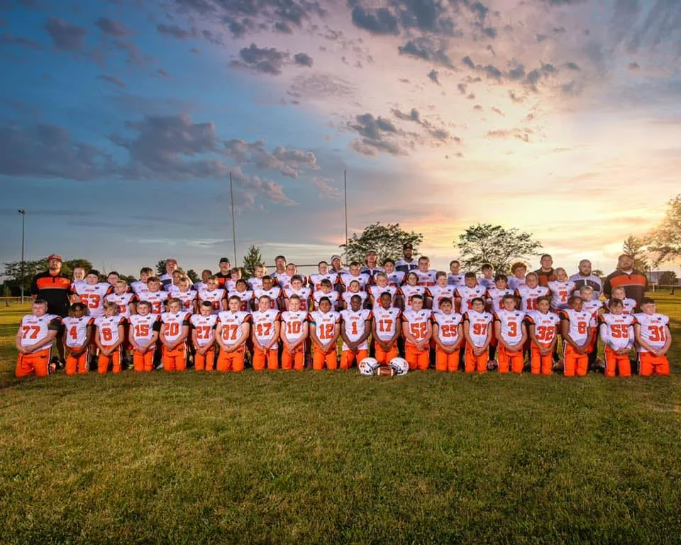The Delaware Jr Pacers team together on the field at sunset